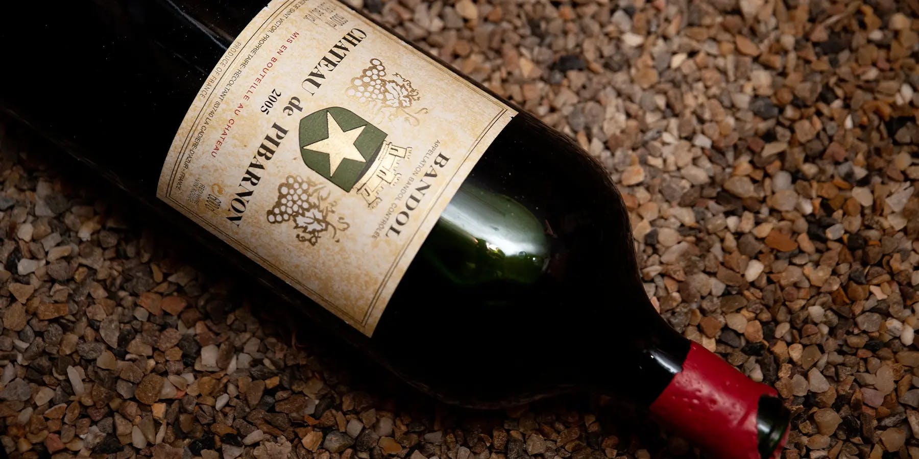 A bottle of Château de Pibarnon 2005 lying on pebbles